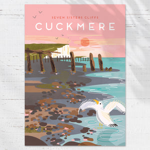 The illustration captures a quiet moment along the shoreline at Cuckmere Haven, with a lone seagull standing at the water’s edge and the iconic Seven Sisters cliffs rising in the distance. Soft light and open sky create a feeling of space and stillness, evoking the timeless beauty of this much-loved stretch of the Sussex coast.