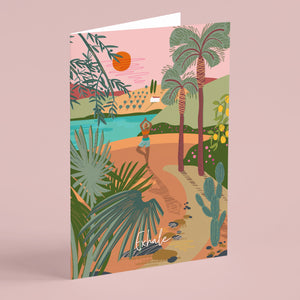Greeting card with a tropical design featuring palm trees and a person on a path doing a yoga pose. The card is named Exhale and is illustrated by onneke