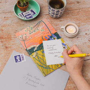 A table top setting with the walking logbook by onneke, a handwritten little card and a grey envelope. Part of a collection of paper goods that make perfect gifts for walkers, hikers, explorers and thos who love the outdoors.
