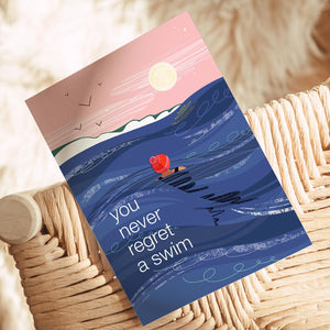 Greeting card with a swimmer in the ocean and text 'you never regret a swim' 