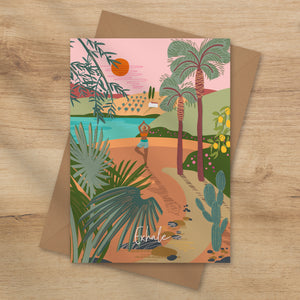 Greeting card with a tropical design featuring palm trees and a person on a path doing a yoga pose. The card is named Exhale and is illustrated by onneke