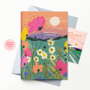 A colorful 'Gratitude Logbook' featuring a vibrant floral landscape illustration with a peach sky and sun, shown with its light grey envelope and a secondary card behind it on a white background.