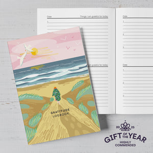 Gratitude logbook with beach illustration and 'Gift of the Year' award badge.