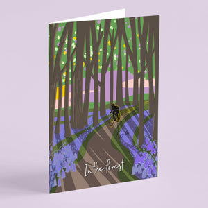 Card with a forest design featuring a cyclist and the text 'In the forest' with blue bells on the forest floor illustration by onneke