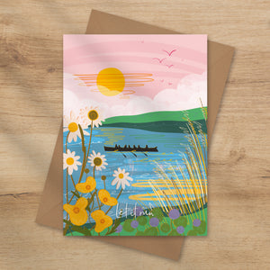 Gig rowers on the river with wild flowers in the foreground and a pink sky with a sun rising