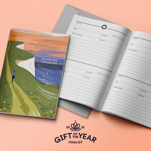 Running logbook with a colorful cover and open pages on a peach background, featuring 'Gift of the Year' finalist logo.