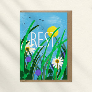 View of the sky as if lying in the gras with grasses and daisies and the word REST. A greeting card illustrated by onneke