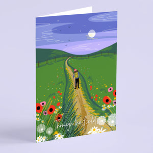 Greeting card with a illustration of a person walking through a field with flowers and a blue sky.