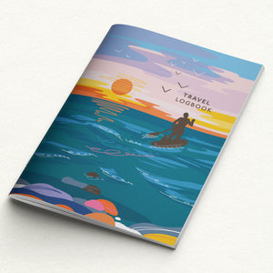 Notebook with a colorful design of a person paddleboarding at sunset, titled 'Travel Logbook'.