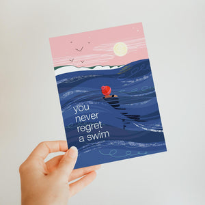 Greeting card with a swimmer in the ocean and text 'you never regret a swim' 